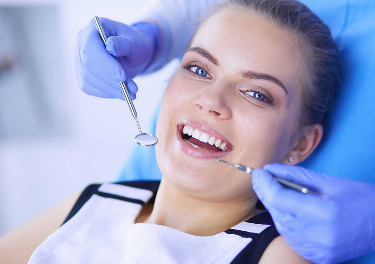 A woman is smiling after teeth whitening